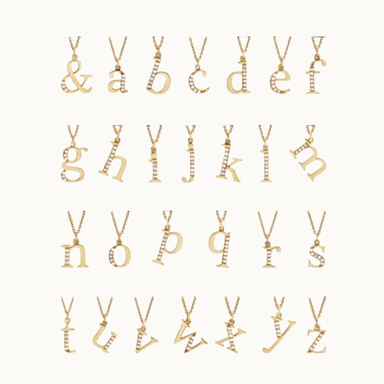 18 carat gold letter or initial charms with labgrown diamonds for each letter of the alphabet on a white background, gemstones are delicate small caps
