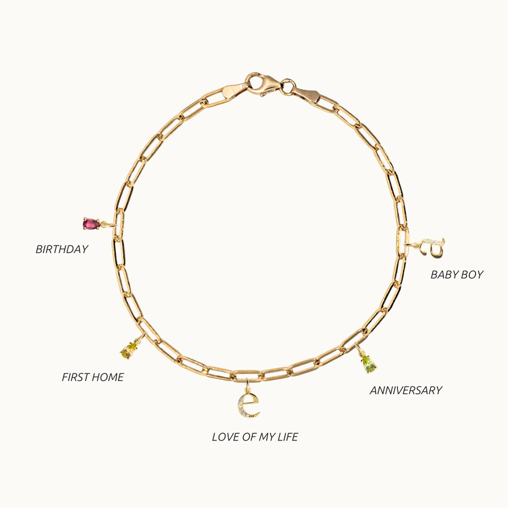 18 carat gold paperclip chain bracelet featuring dangling gemstone charms, birthstone charm bracelet and an initial or letter charm with labgrown diamonds on a chunky chain, showing occasions or moments to gift this bracelet