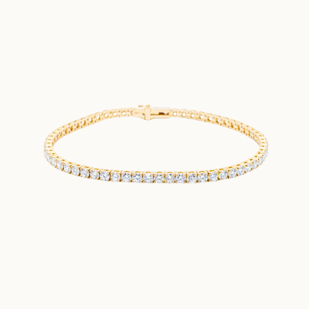 Elegant gold tennis bracelet featuring a continuous row of round brilliant labgrown diamonds in a classic prong setting.