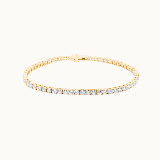 Elegant gold tennis bracelet featuring a continuous row of round brilliant labgrown diamonds in a classic prong setting.