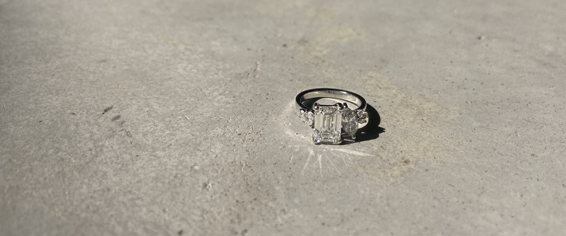 Fine jewelry toi et moi custom design cluster engagement ring in 18k recycled white gold set with emerald cut and marquise cut lab-grown diamonds, shown in close-up