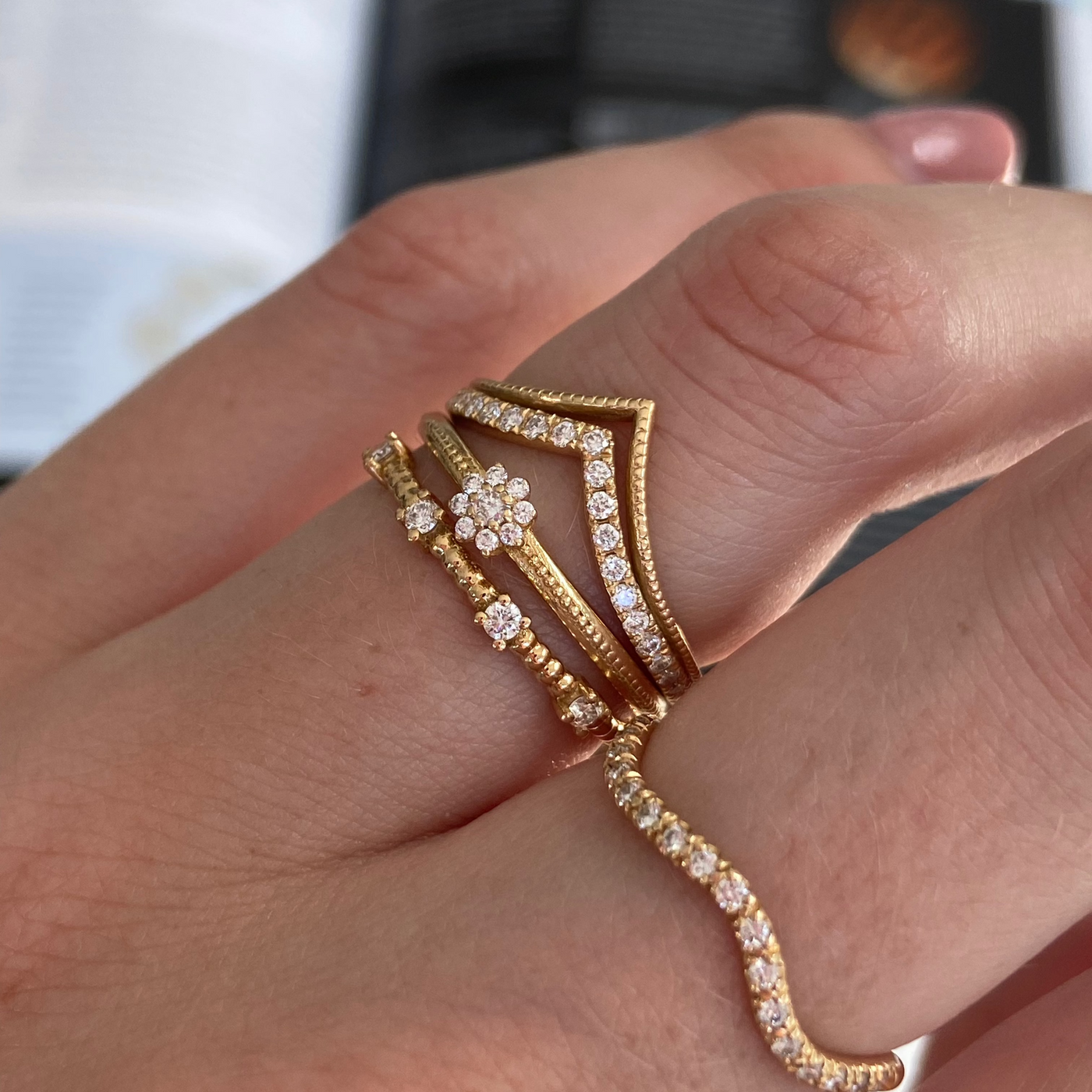 Camellia Ring stacked with diamond crown rings and the Cordelia Ring on the hand