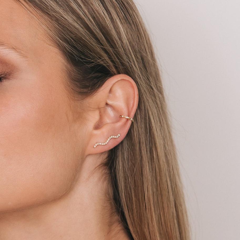 Model wearing the Daisy Ear Cuff in an ear stack with a wave ear climber