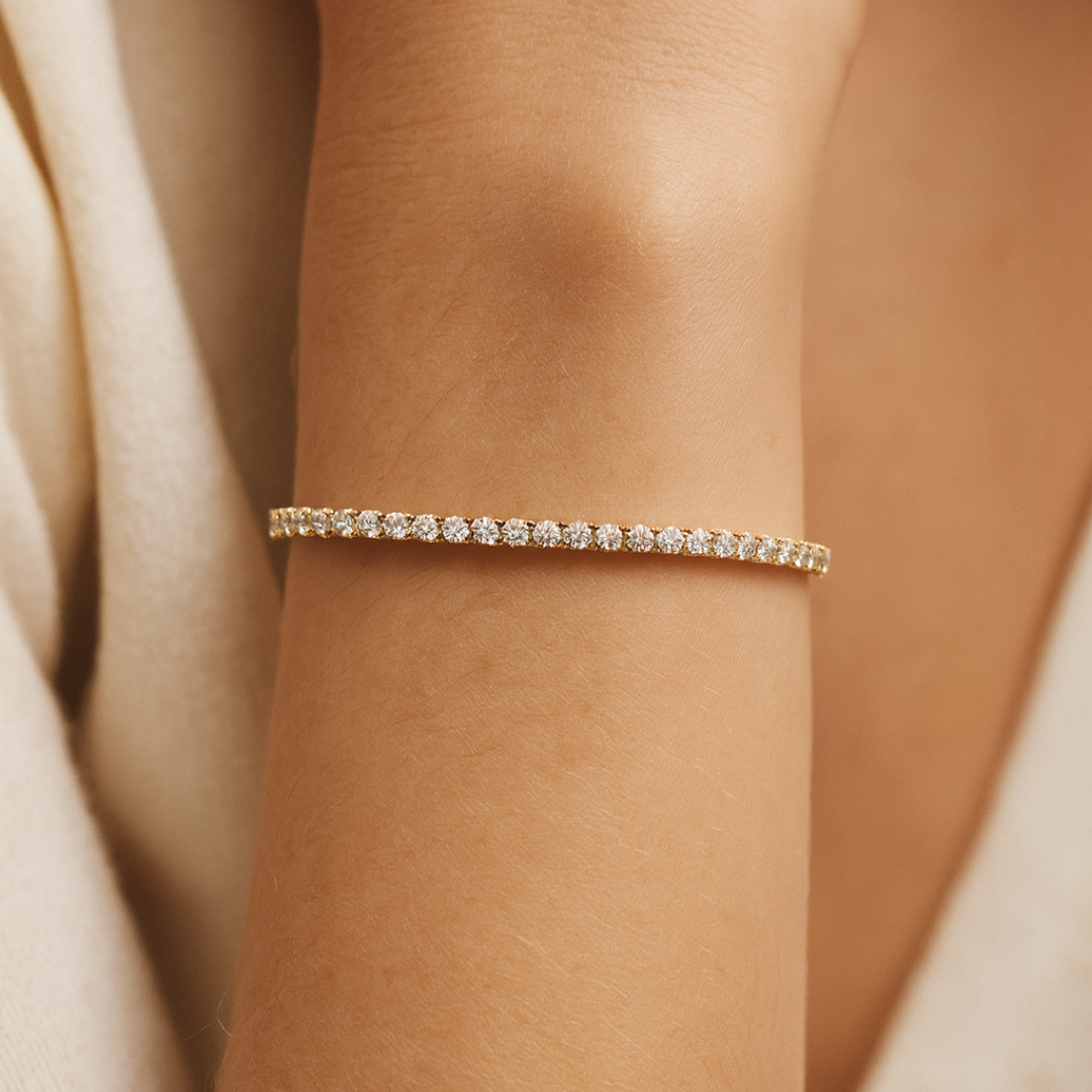Model wearing elegant gold tennis bracelet featuring a continuous row of round brilliant labgrown diamonds in a classic prong setting.