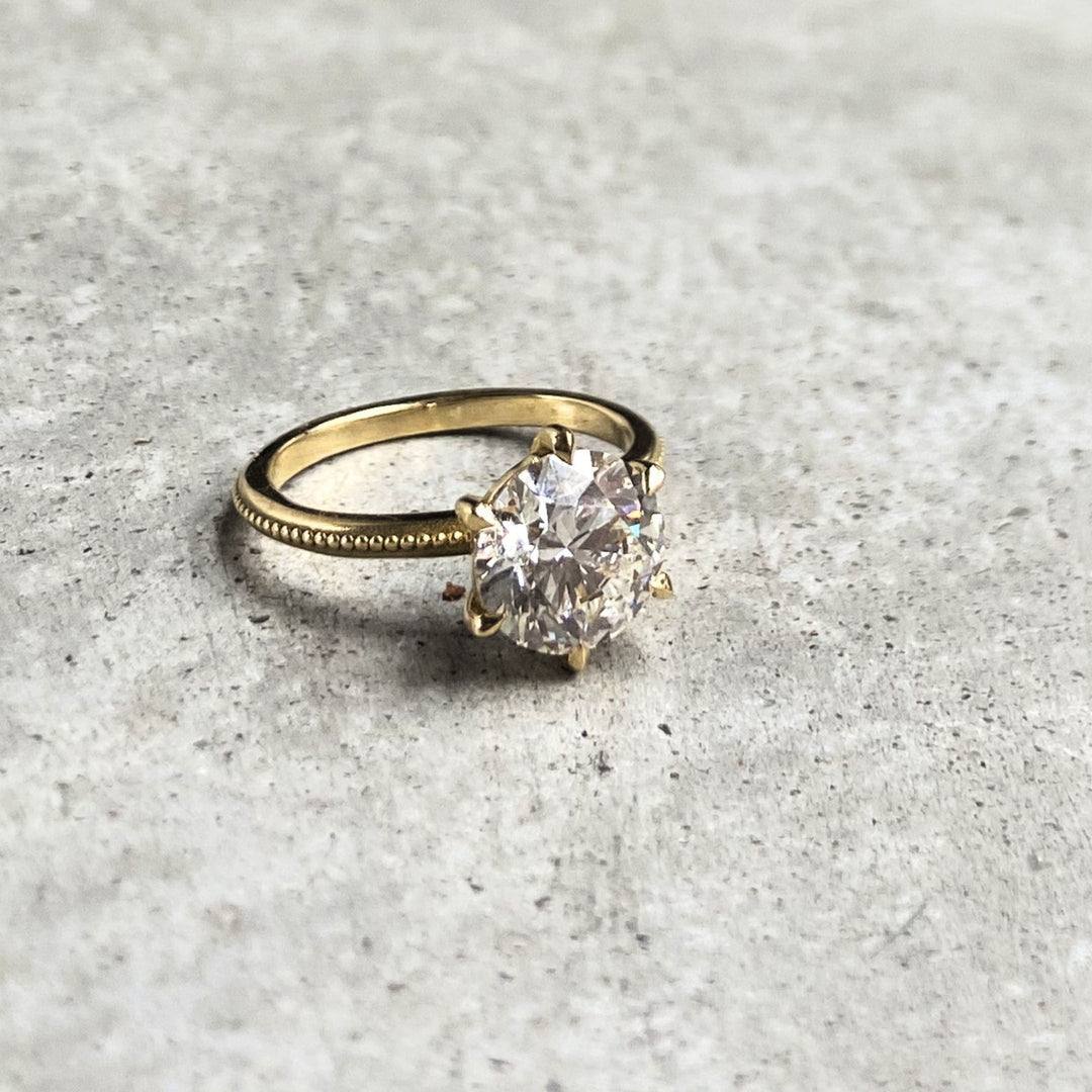 Laurel Solitaire on stone, a round lab-grown diamond in six claws on a beaded band, recycled 18K yellow gold