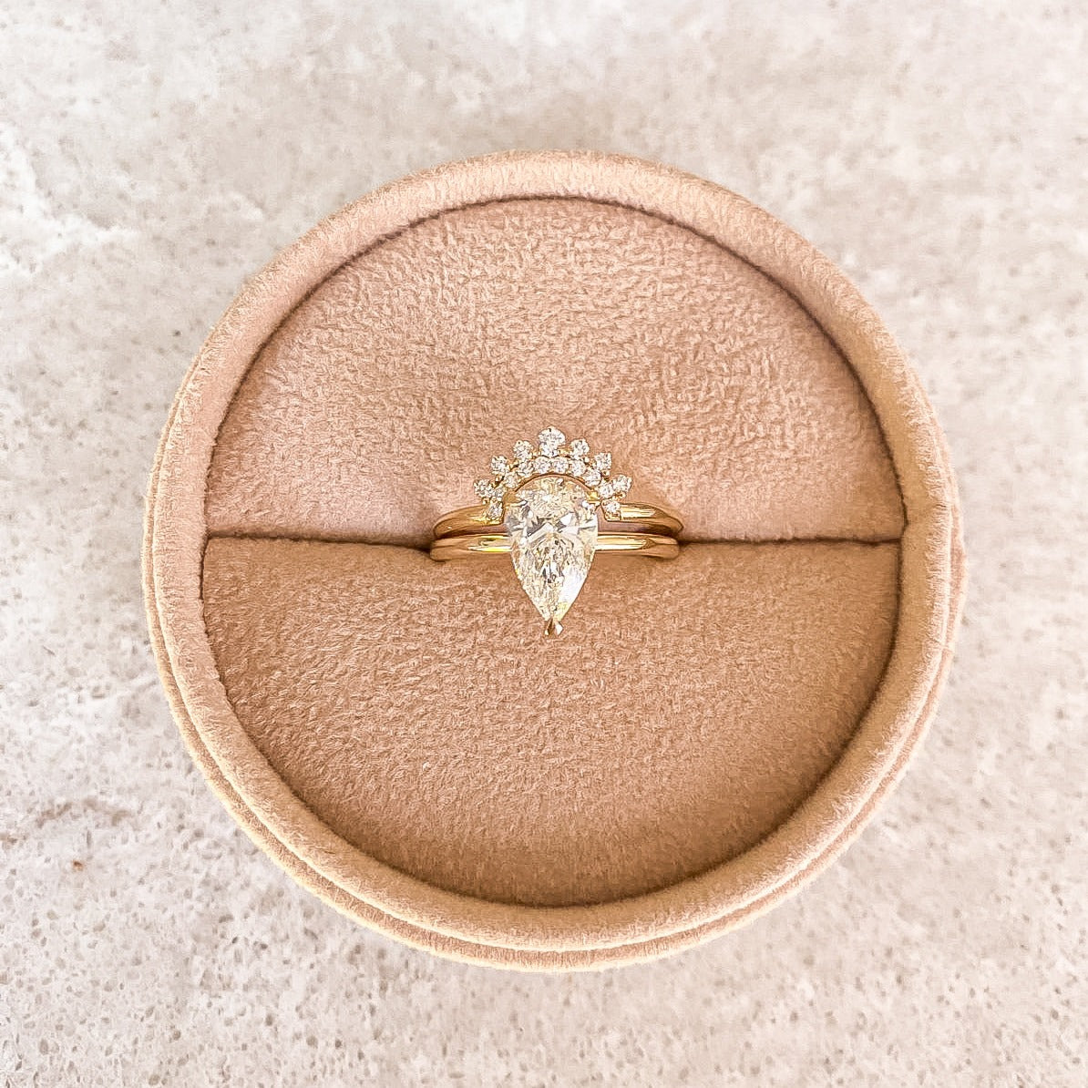 Primrose Pear stacked with a diamond crown band in a velvet ring box, recycled 18K yellow gold