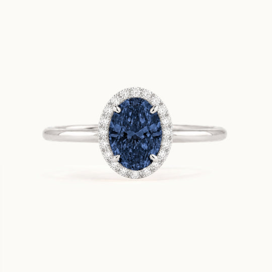 Dahlia Sapphire Ring, an oval blue sapphire in a lab-grown diamond halo, recycled 18K white gold