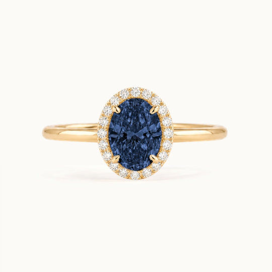 Dahlia Sapphire Ring, an oval blue sapphire in a lab-grown diamond halo, recycled 18K yellow gold