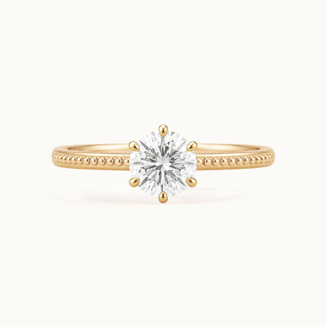 Laurel Ring, a round lab-grown diamond in six claws on a beaded band, recycled 18K yellow gold
