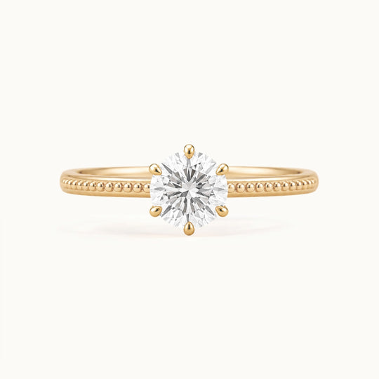 Laurel Ring, a round lab-grown diamond in six claws on a beaded band, recycled 18K yellow gold