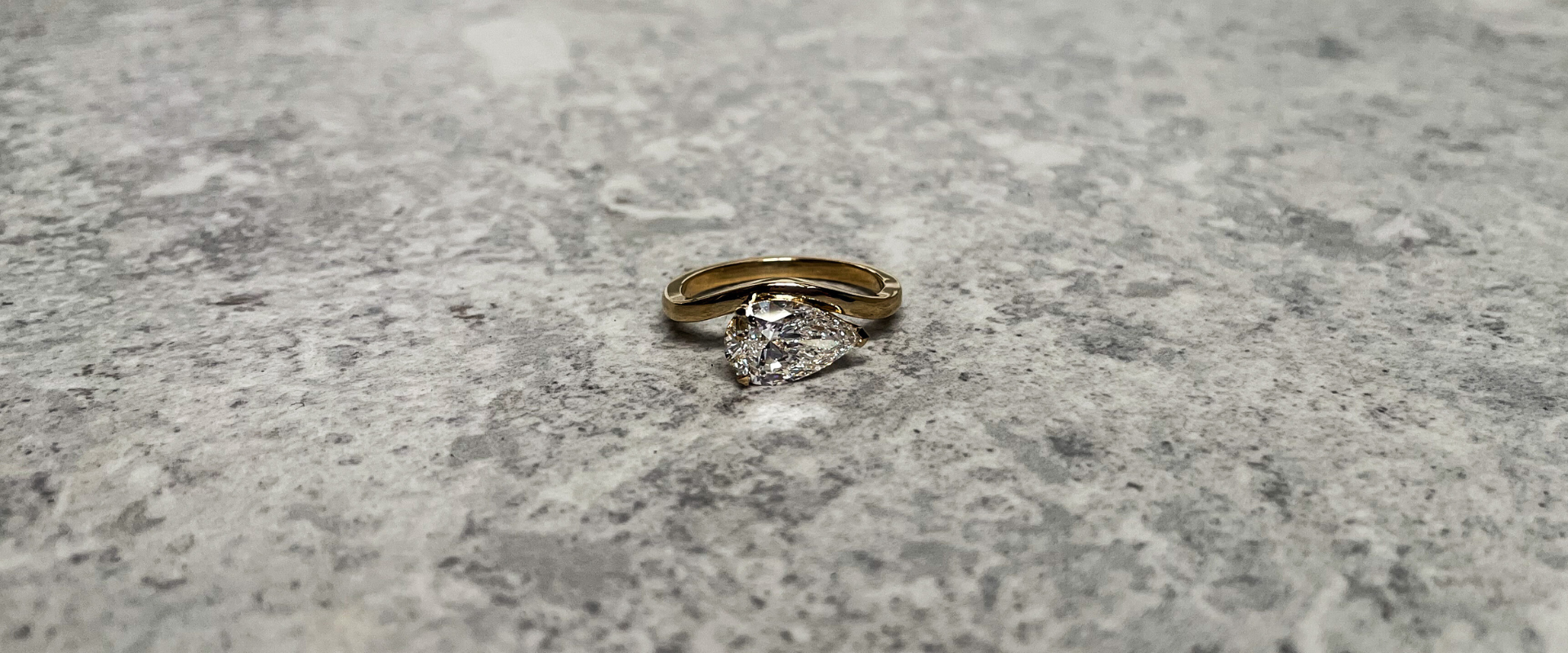 Wavey ring with pear-cut lab-grown diamond engagement ring on a wave band, handmade in recycled 18K gold at Juna Fae Antwerp.