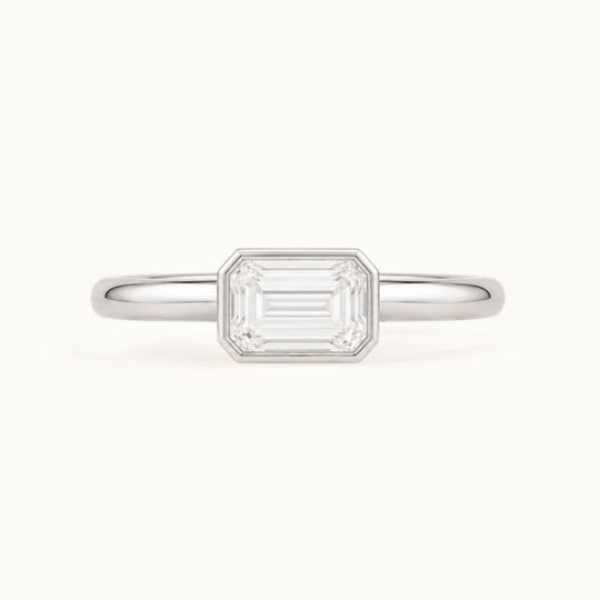 Simone Ring, an east-west emerald-cut lab-grown diamond in a bezel, recycled 18K white gold