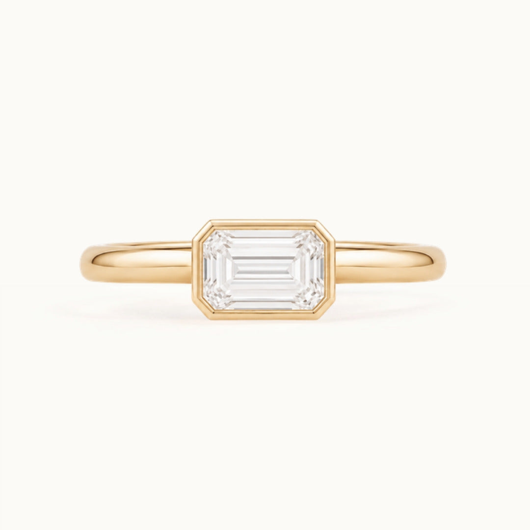 Simone Ring, an east-west emerald-cut lab-grown diamond in a bezel, recycled 18K yellow gold