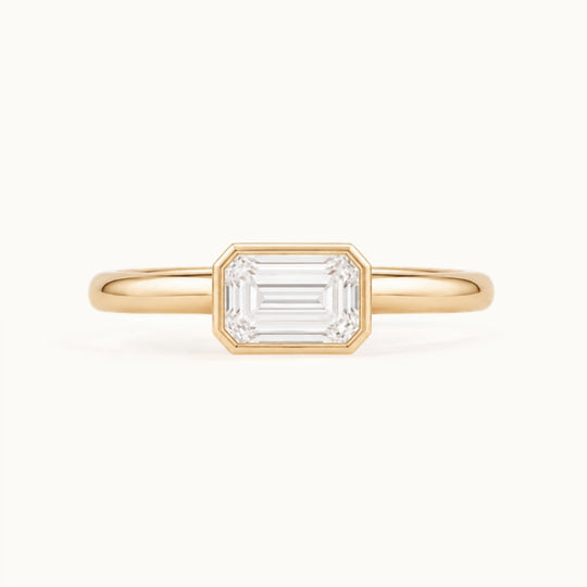 Simone Ring, an east-west emerald-cut lab-grown diamond in a bezel, recycled 18K yellow gold