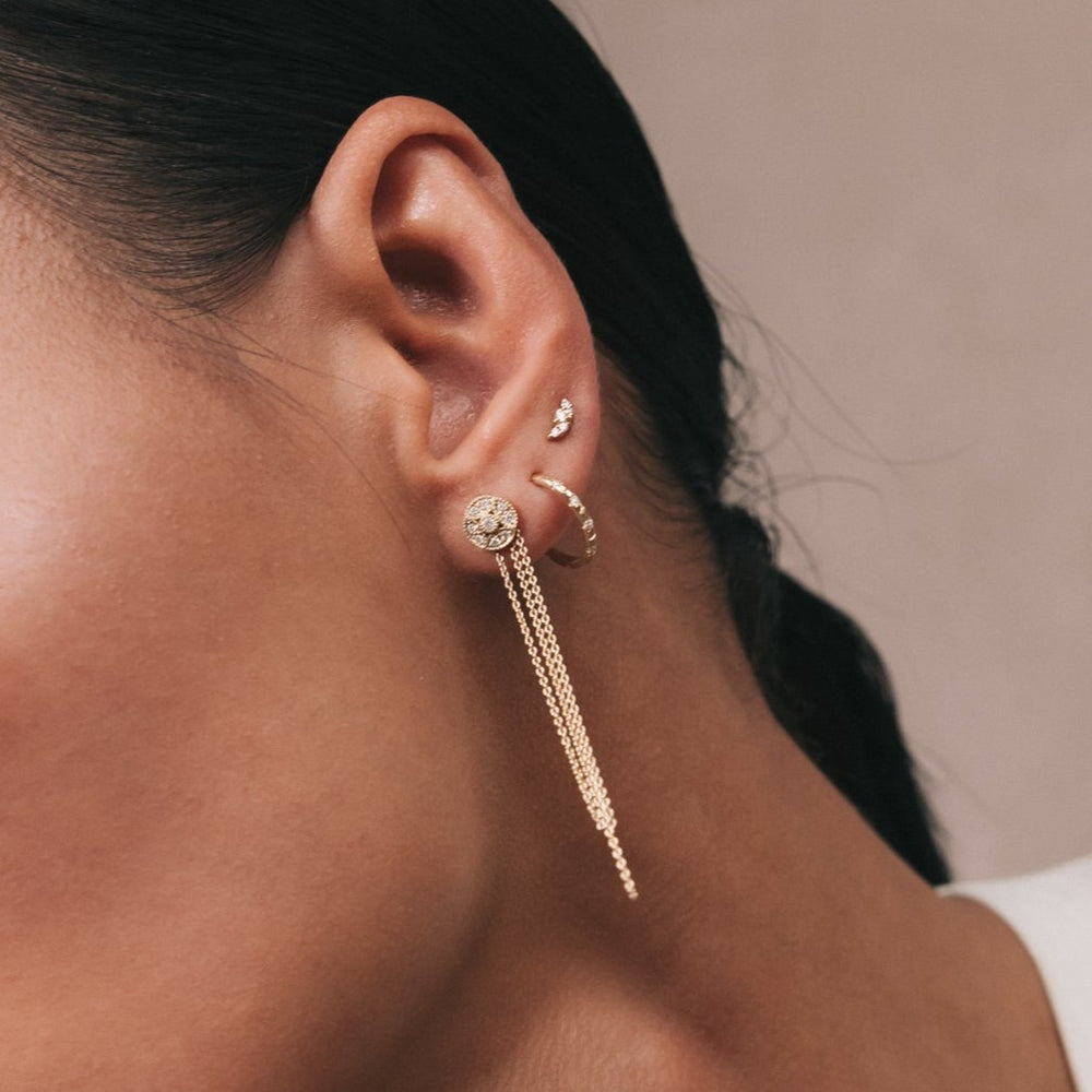 Model wearing the Daisy lab-grown diamond hoop with chain add-on in recycled 18K yellow gold